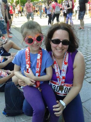 Woman and child wearing sunglasses and medals running