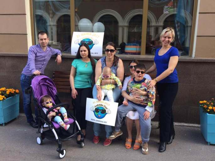 5 adults and 3 children with Aniridia Day signs