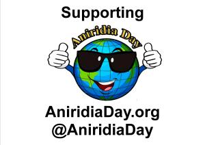 Poster showing the Aniridia Day logo - a cartoon image of the Earth, wearing sunglasses, smiling and giving 2 thumbs up. Above this are the words Supporting Aniridia Day. Below it is the website address AniridiaDay.org and the Twitter handle @AniridiaDay.