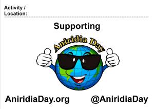 Poster showing the Aniridia Day logo - a cartoon image of the Earth, wearing sunglasses, smiling and giving 2 thumbs up. Above it is a space to enter an activity or location, followed by the words Supporting Aniridia Day. Below it is the website address AniridiaDay.org and the Twitter handle @AniridiaDay.