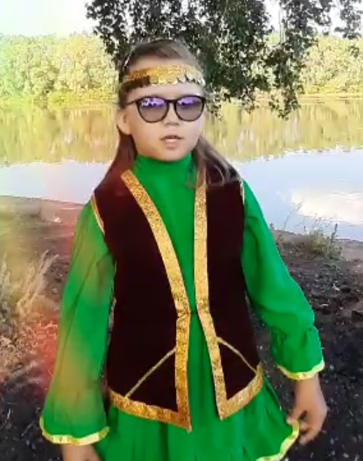 Andryushina wearing traditional green and black clothes of Bashkortostan